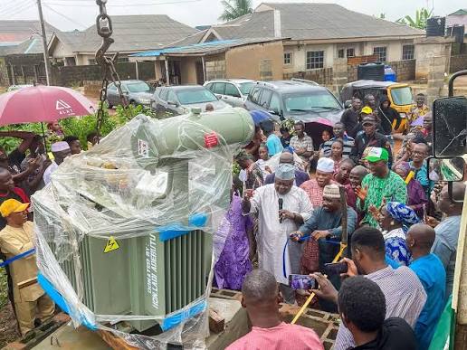 Community members gathered during installation of a LADO-donated transformer